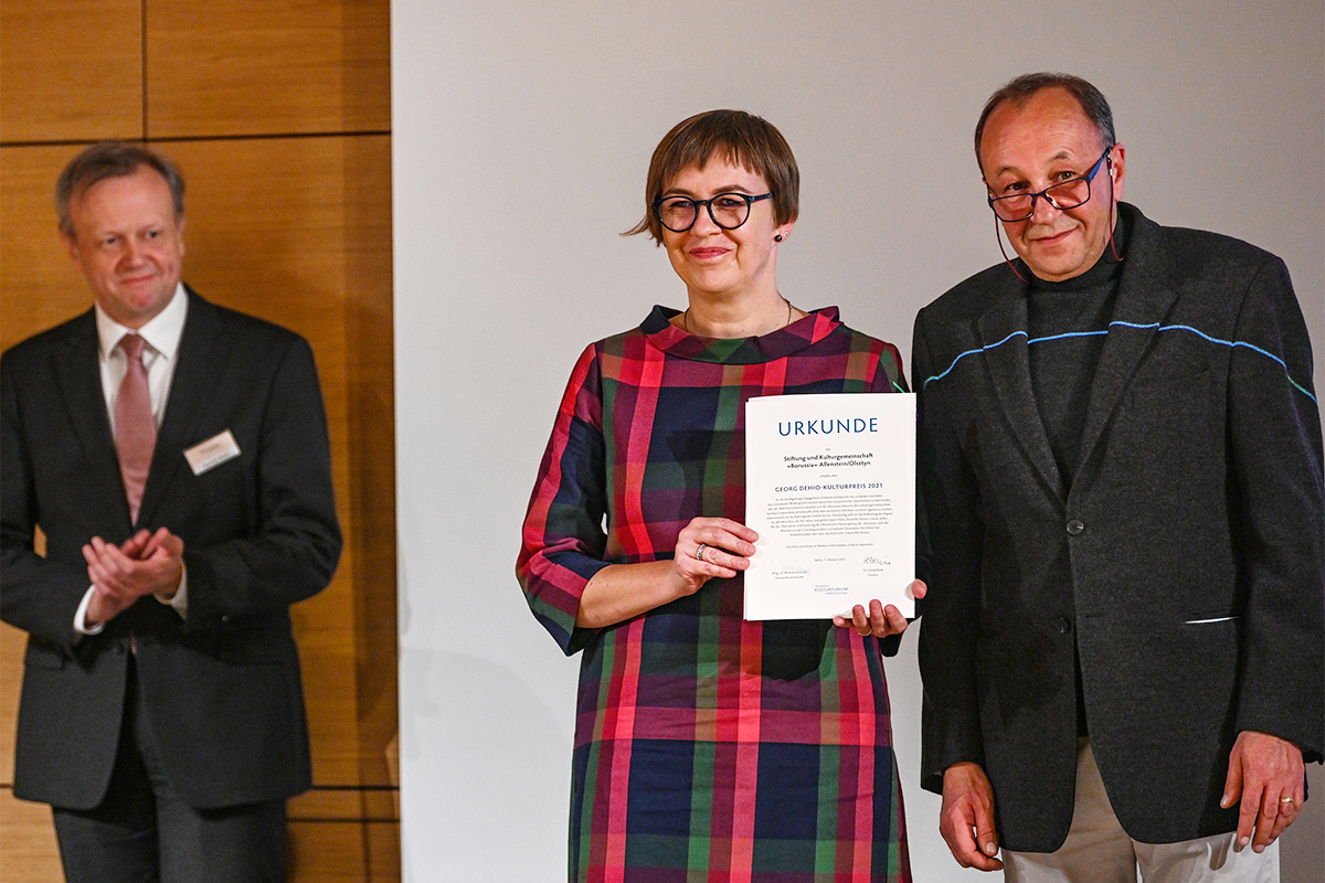 Prof. Dr. Robert Traba und Kornelia Kurowska nahmen den Georg Dehio-Kulturpreis 2021 (Hauptpreis) für die »Borussia« für ihr über drei Jahrzehnte währendes Engagement der Bewahrung und Vermittlung des kulturellen Erbes in der Woiwodschaft Ermland-Masuren entgegen. Links Dr. Harald Roth, Direktor des Deutschen Kulturforums. | Foto: © Deutsches Kulturforum östliches Europa • Fotografin: Anke Illing Prof. Dr. Robert Traba und Kornelia Kurowska nahmen den Georg Dehio-Kulturpreis 2021 (Hauptpreis) für die »Borussia« für ihr über drei Jahrzehnte währendes Engagement der Bewahrung und Vermittlung des kulturellen Erbes in der Woiwodschaft Ermland-Masuren entgegen. Links Dr. Harald Roth, Direktor des Deutschen Kulturforums.